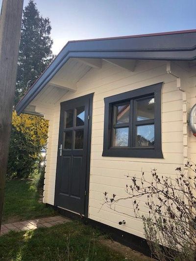 Ein Haus mit einer Fassade aus Holz und dunkler Tür